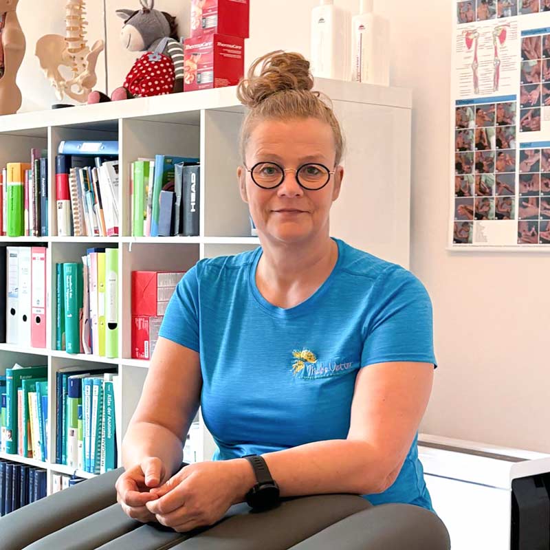 Maike Oetter im Behandlungszimmer hinter einer Behandlungsliege